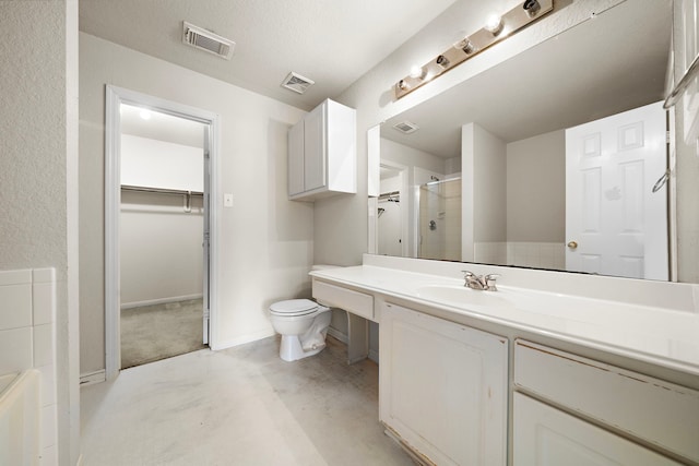 bathroom with toilet, a shower with door, and vanity