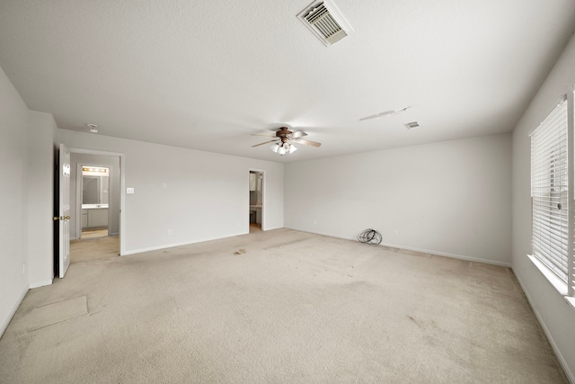 carpeted empty room featuring ceiling fan and plenty of natural light