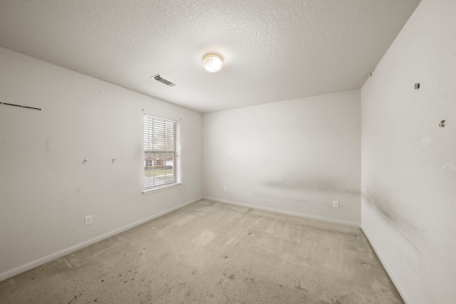 carpeted spare room featuring a textured ceiling