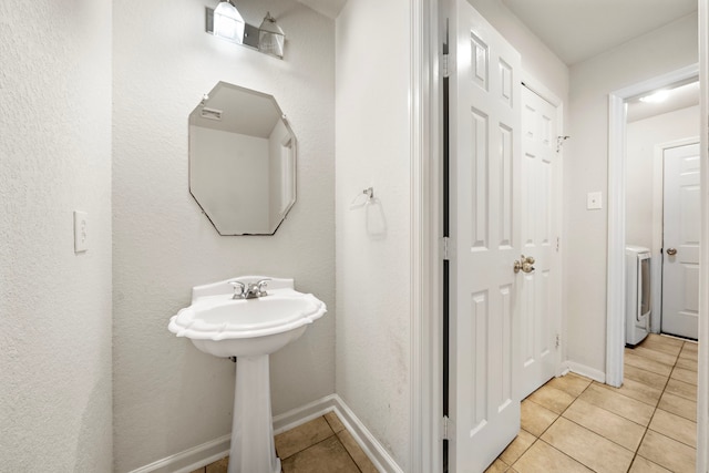 bathroom with washer / clothes dryer and tile patterned flooring