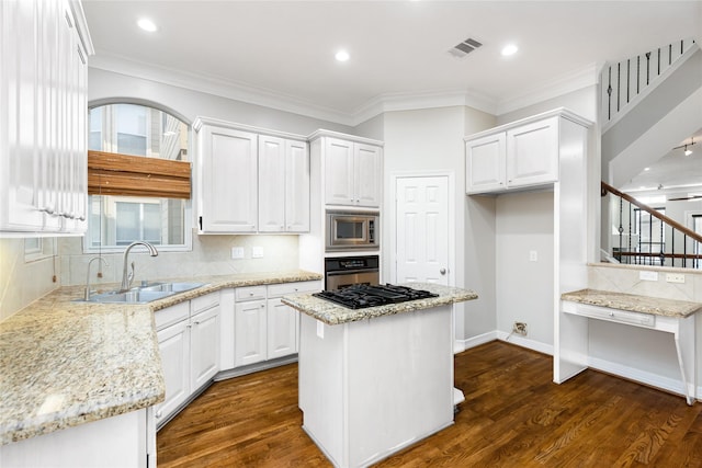 kitchen featuring stainless steel appliances, a kitchen island, white cabinets, and light stone counters