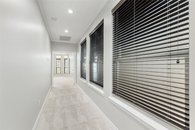 hall featuring crown molding and light colored carpet