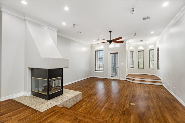 unfurnished living room with ornamental molding, ceiling fan, a multi sided fireplace, and wood-type flooring