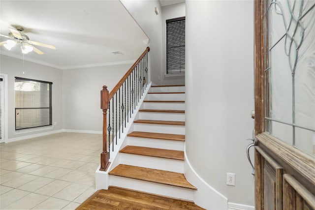 stairway with tile patterned flooring, crown molding, and ceiling fan