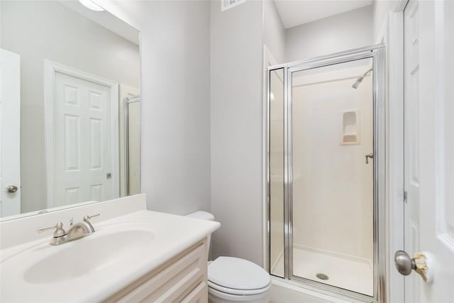 bathroom featuring vanity, an enclosed shower, and toilet