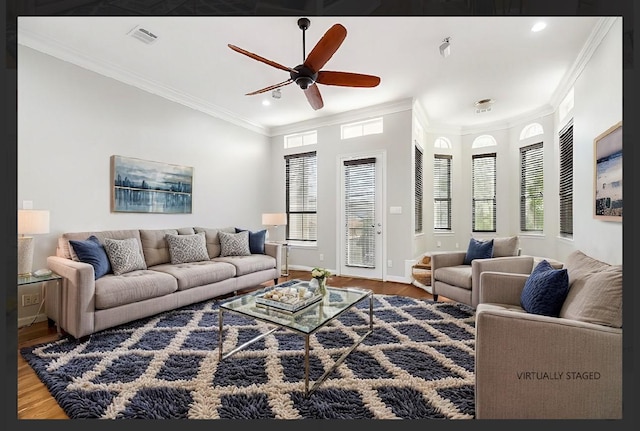 living room with a wealth of natural light, wood-type flooring, and ornamental molding