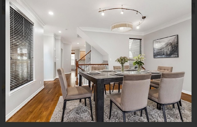 dining space with crown molding, track lighting, and dark hardwood / wood-style floors