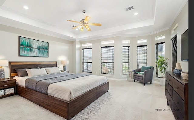 carpeted bedroom featuring ornamental molding, ceiling fan, and a tray ceiling