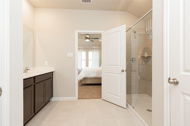 bathroom featuring tile patterned flooring, vanity, vaulted ceiling, and a shower with door