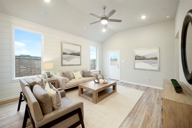 living room featuring light wood-type flooring, ceiling fan, and vaulted ceiling