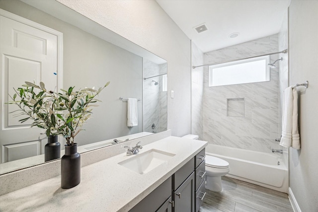 full bathroom with toilet, vanity, and tiled shower / bath combo