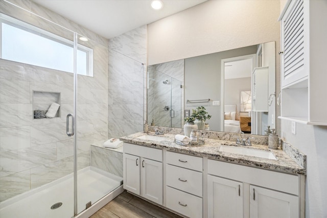 bathroom with a shower with door and vanity