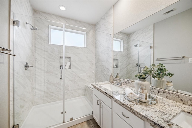 bathroom featuring an enclosed shower, vanity, and hardwood / wood-style floors