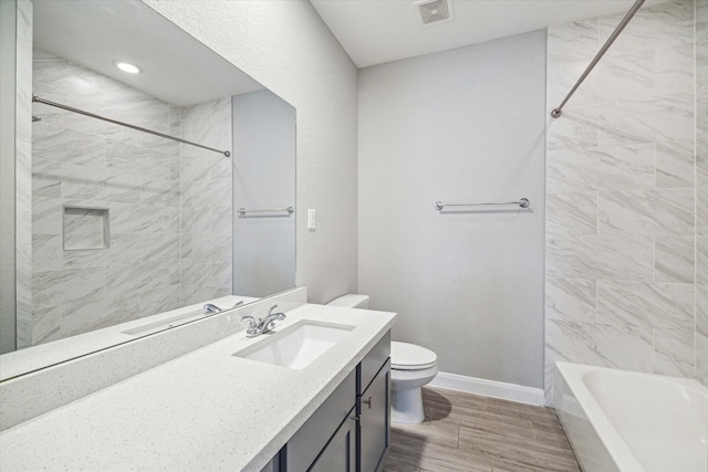 full bathroom with toilet, tiled shower / bath, and vanity