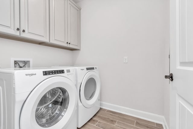 washroom with separate washer and dryer and cabinets