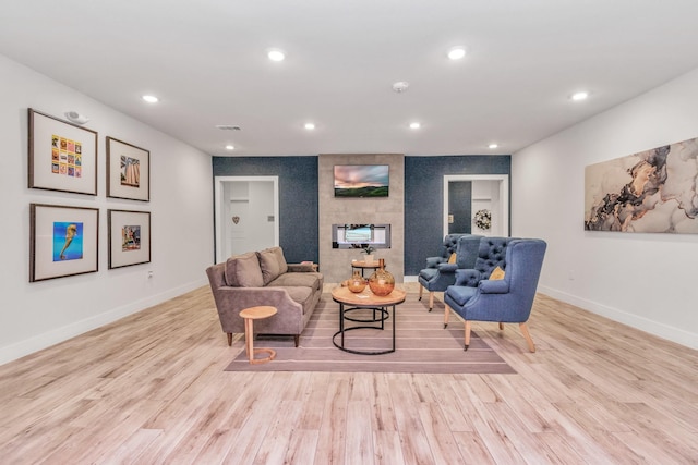 living room with light hardwood / wood-style flooring and a tile fireplace