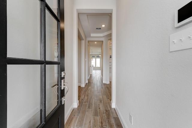 hallway with recessed lighting, visible vents, baseboards, and wood finished floors