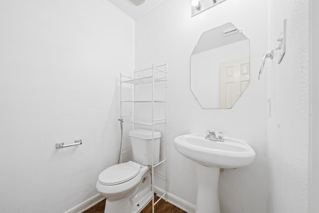 bathroom featuring toilet and wood-type flooring