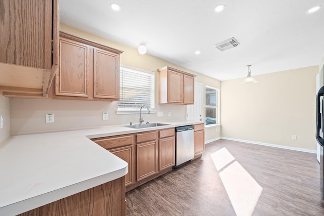 kitchen with stainless steel dishwasher, wood-type flooring, pendant lighting, and sink