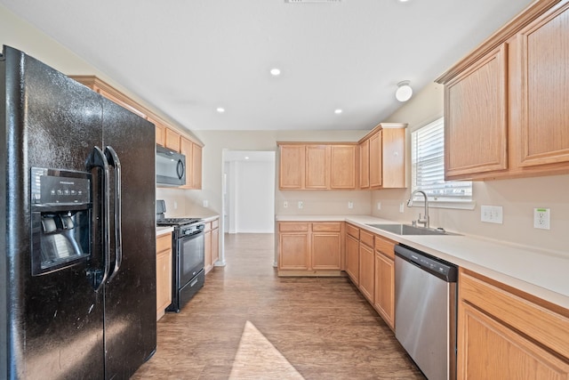 kitchen featuring black appliances, light wood-type flooring, sink, and light brown cabinets