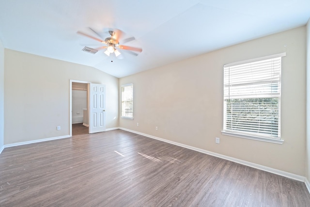 empty room featuring ceiling fan, vaulted ceiling, and dark hardwood / wood-style floors