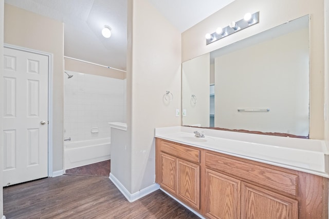 bathroom featuring hardwood / wood-style flooring, shower / bath combination, and vanity