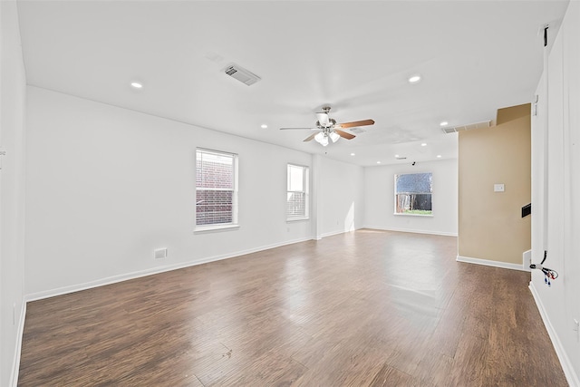 unfurnished living room featuring ceiling fan and dark wood-type flooring