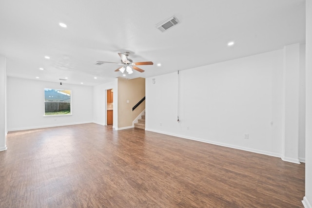 unfurnished living room featuring ceiling fan and dark wood-type flooring