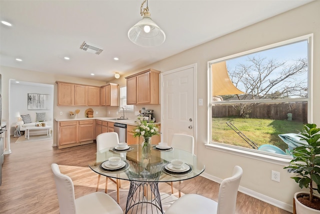 dining space with sink, light hardwood / wood-style flooring, and plenty of natural light