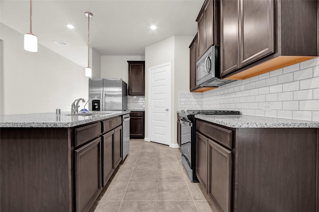 kitchen with pendant lighting, stainless steel appliances, light tile patterned floors, dark brown cabinets, and sink