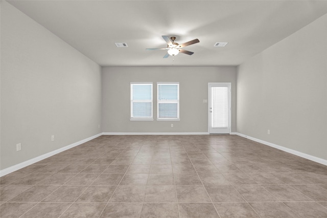 tiled spare room featuring ceiling fan