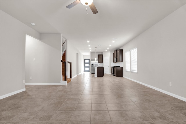 unfurnished living room featuring ceiling fan and light tile patterned floors