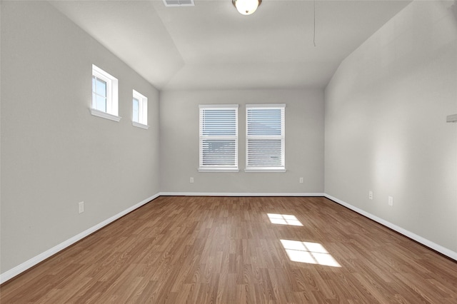 empty room with lofted ceiling and light hardwood / wood-style flooring