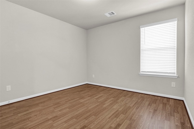 spare room featuring a healthy amount of sunlight and hardwood / wood-style flooring