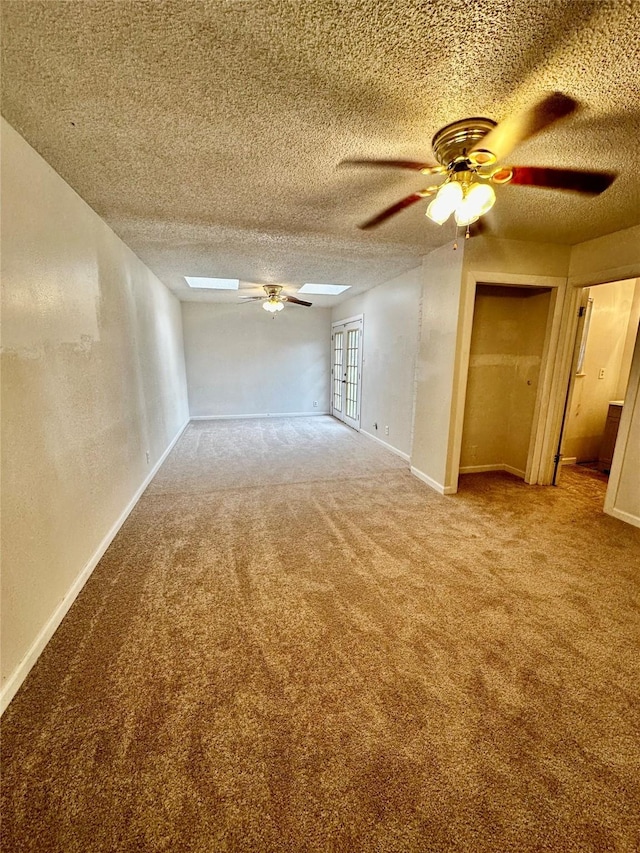 unfurnished room featuring a textured ceiling, ceiling fan, and carpet