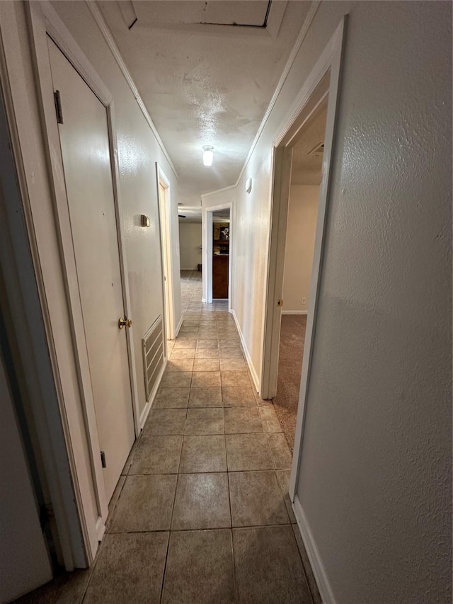 hall with tile patterned flooring and ornamental molding