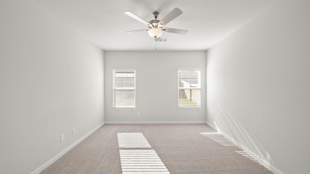 empty room with ceiling fan and light carpet