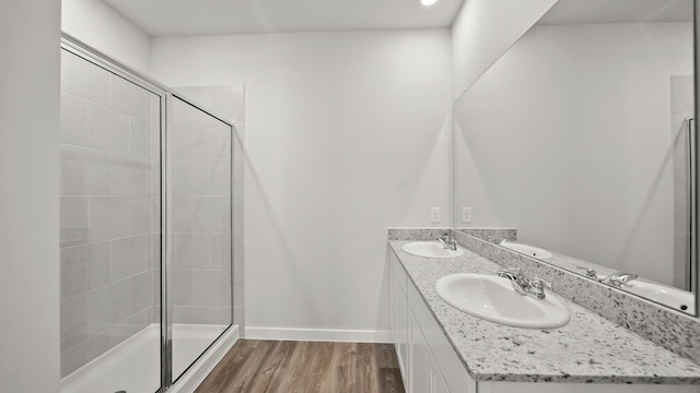 bathroom with hardwood / wood-style flooring, an enclosed shower, and vanity