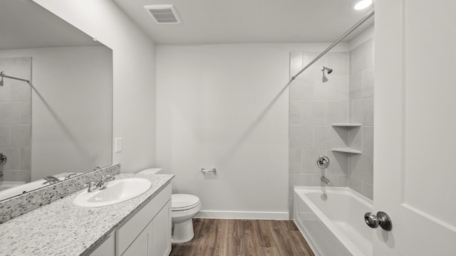 full bathroom featuring toilet, tiled shower / bath combo, vanity, and hardwood / wood-style floors