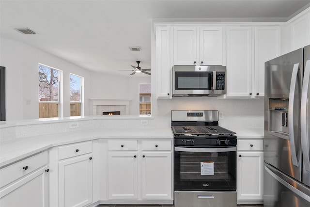 kitchen with white cabinetry, visible vents, appliances with stainless steel finishes, and light countertops