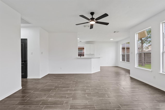 unfurnished living room featuring ceiling fan, wood finish floors, and baseboards