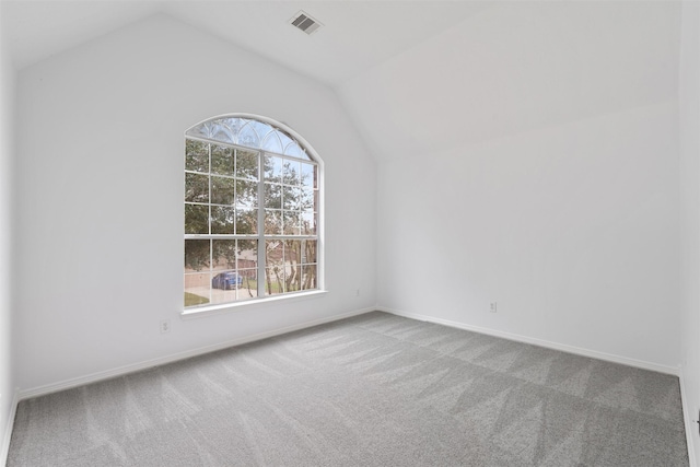 unfurnished room with carpet floors, lofted ceiling, visible vents, and baseboards