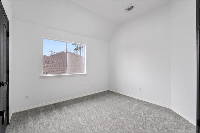 empty room featuring vaulted ceiling, carpet, visible vents, and baseboards