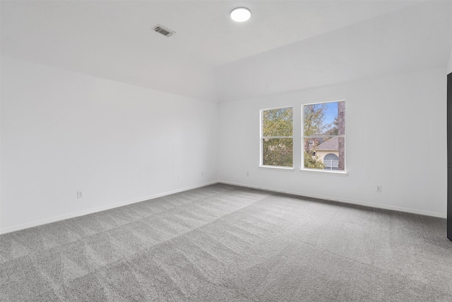 spare room with lofted ceiling, carpet flooring, visible vents, and baseboards