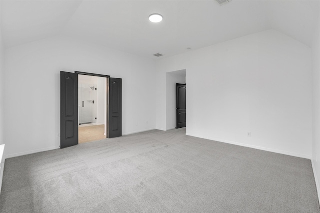 unfurnished room featuring baseboards, visible vents, vaulted ceiling, and carpet flooring