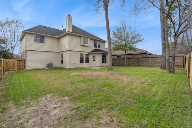 rear view of property featuring a yard, a chimney, central AC, a patio area, and a fenced backyard