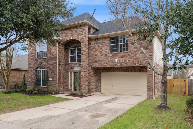 traditional-style house with driveway, brick siding, a front lawn, and fence