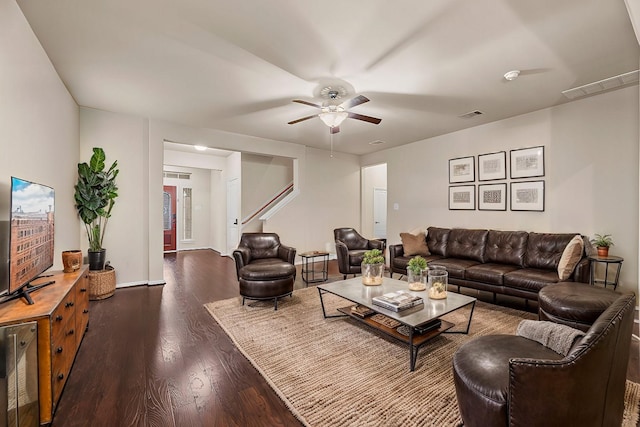 living room featuring ceiling fan and dark wood-type flooring