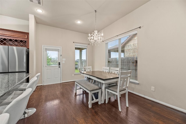 dining area with dark hardwood / wood-style flooring and a notable chandelier