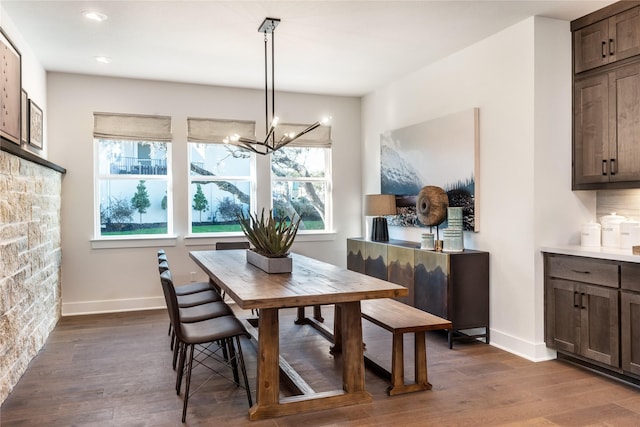 dining space featuring an inviting chandelier and dark wood-type flooring